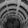 A grayscale view of a spiral concrete parking garage with geometric design elements.