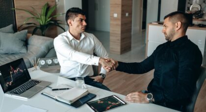 Two men shaking hands in an office, symbolizing successful agreement or partnership.